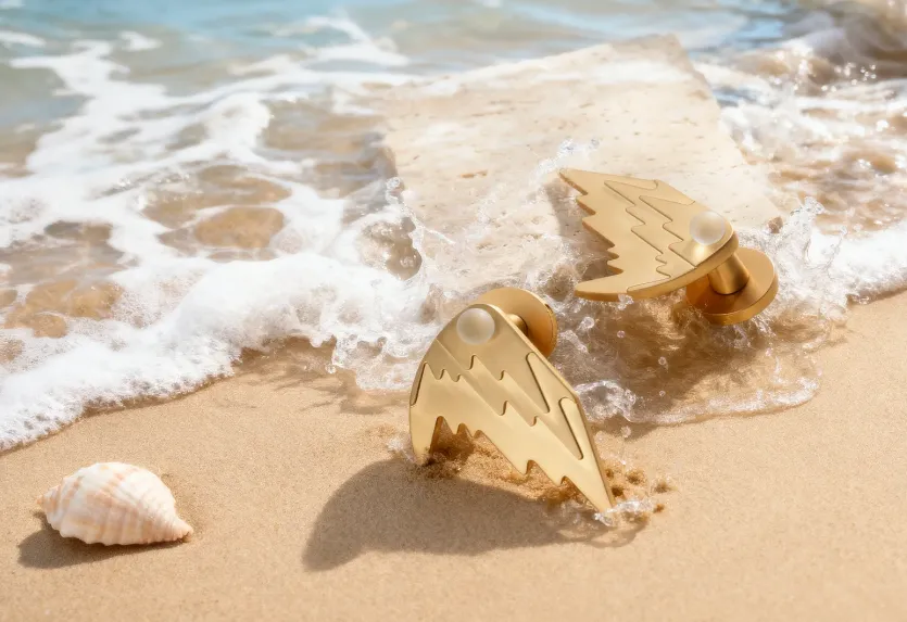 Détail de la poignée OCEANIQUE en laiton doré et cristal clair, design d’inspiration marine